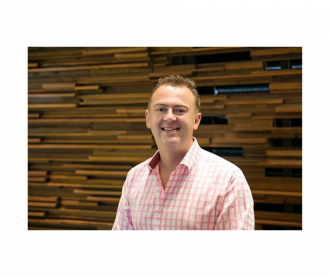 Garth Solly smiling at camera wearing pink shirt