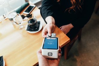 Man holding out an eftpos machine to customer with card