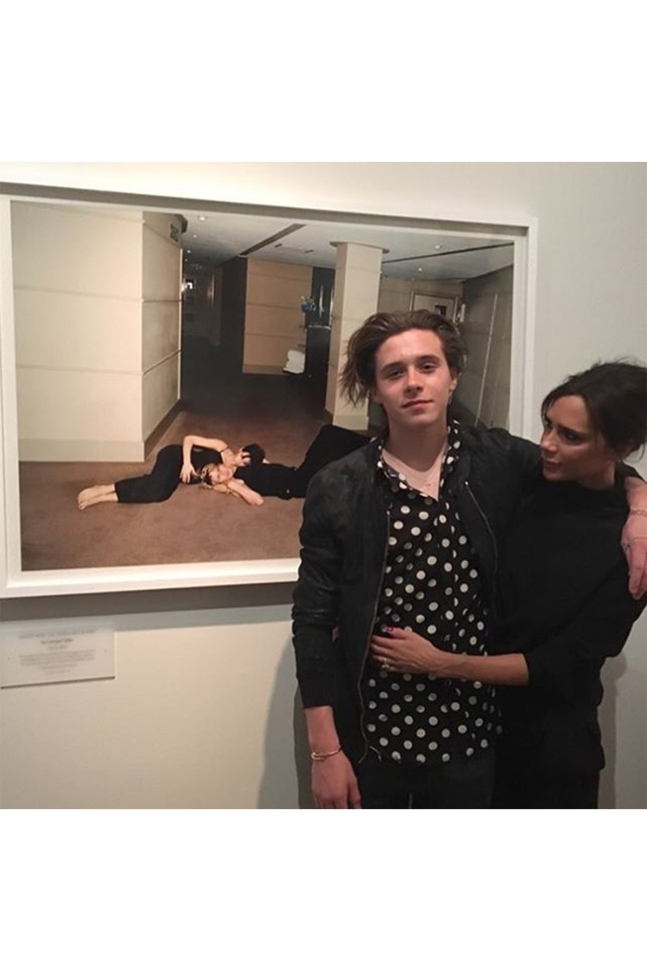 Victoria Beckham with her son Brooklyn Beckham in front of a photograph of her carrying oldest son with David Beckham. The photograph hangs at the Vogue 100: A Century Of Style exhibition at the National Portrait Gallery. 