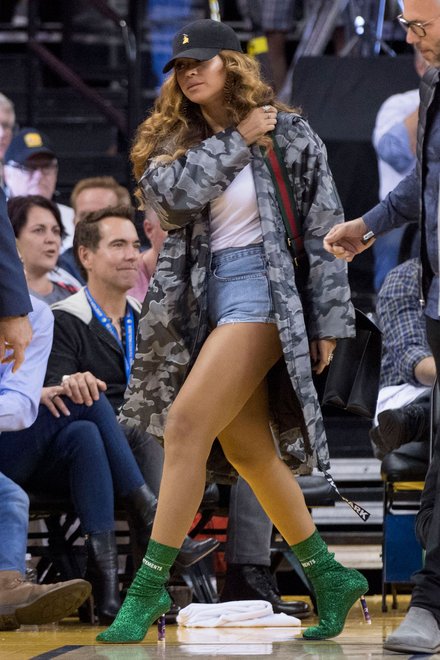GOING GREEN // Beyoncé took centre stage on the basketball court this week donning a pair of sparkling green Lurex sock boots complete with a unicorn printed heel from Vetements. 
