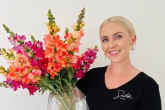 SilkSense Flowers Auckland Owner Alana, with a vase of silk flowers