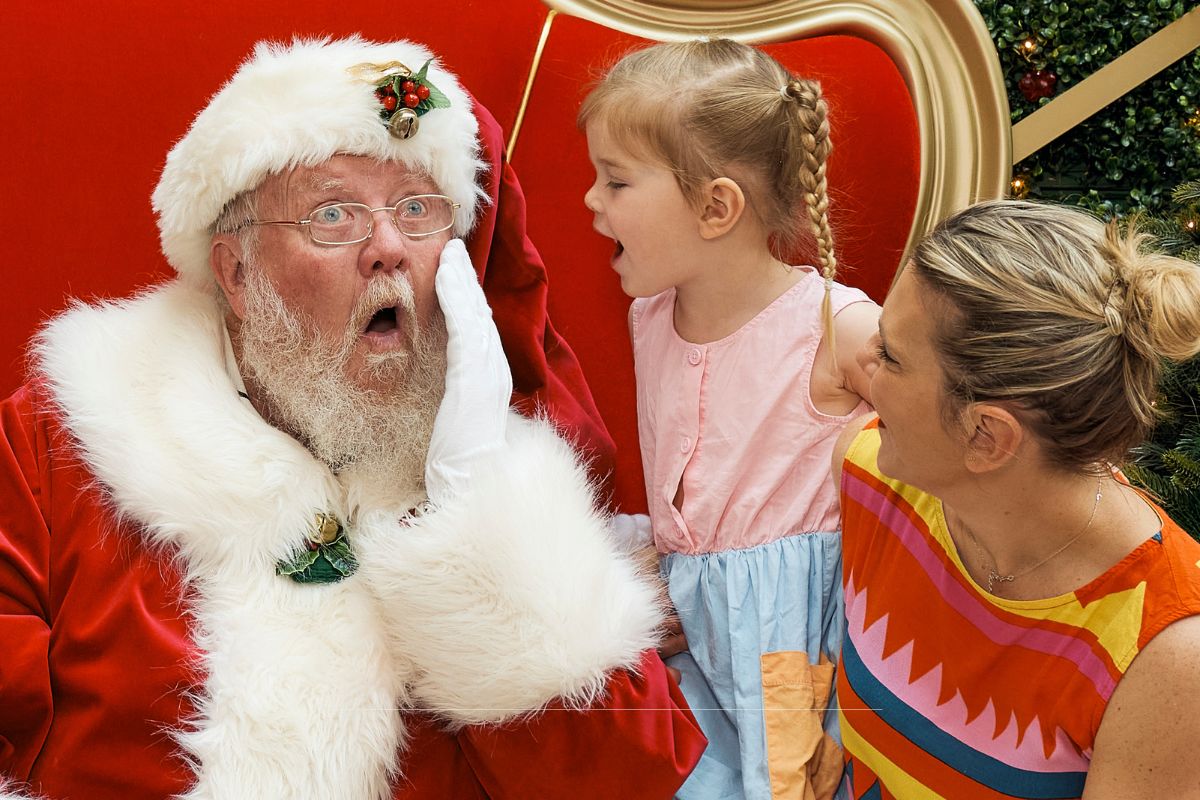 Girl telling Santa what she wants for Christmas