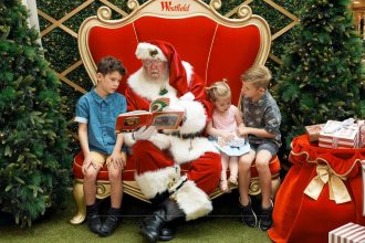 Children with Santa on red throne