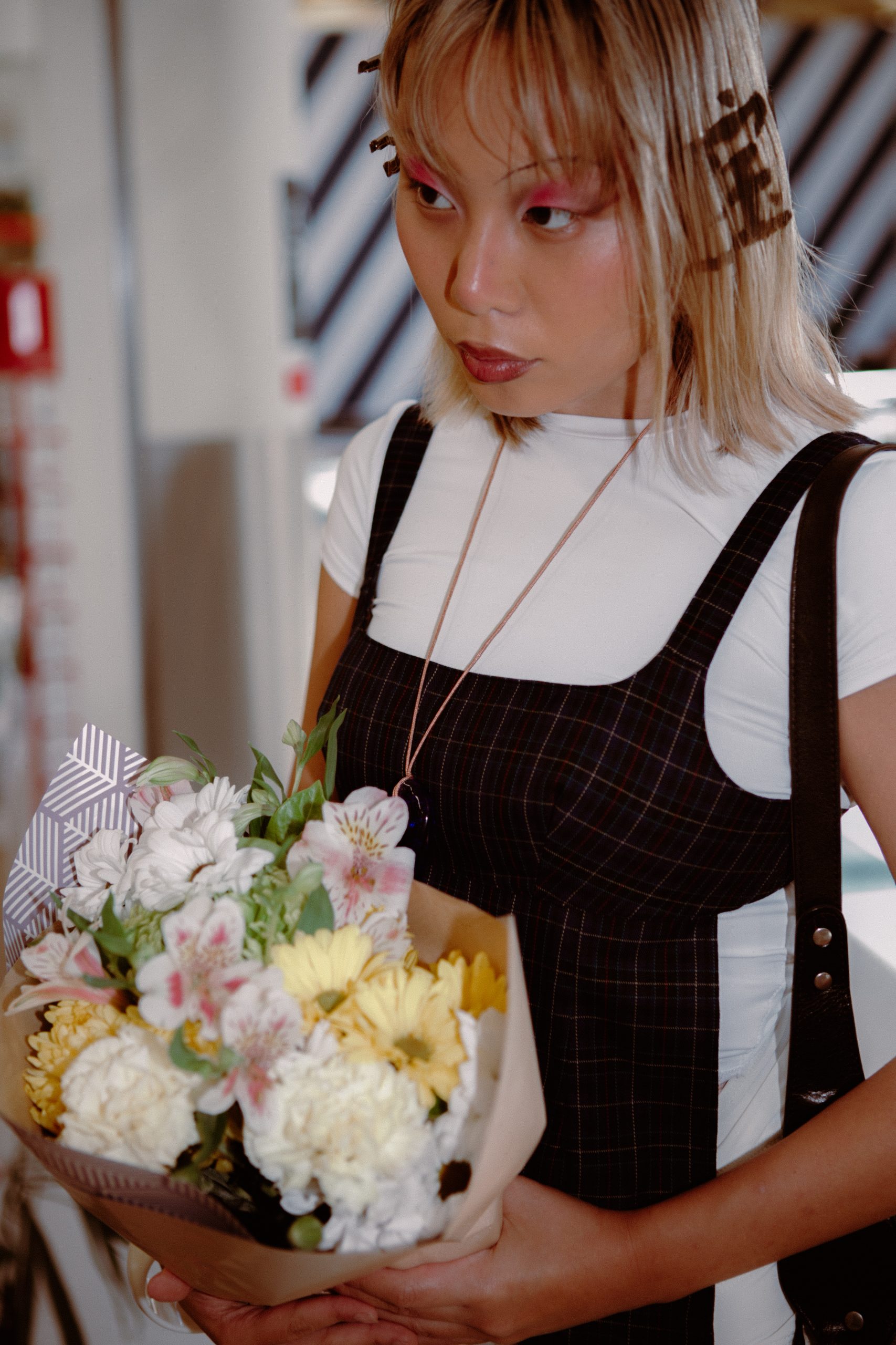 Woman Holding Flowers with Chinese Characters Sprayed Into Hair