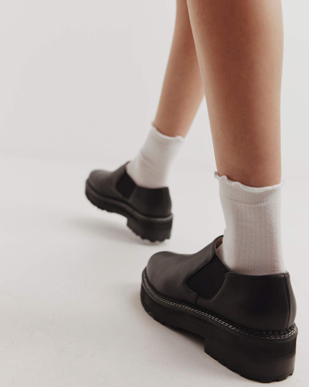 Woman wearing black ankle boots with white socks