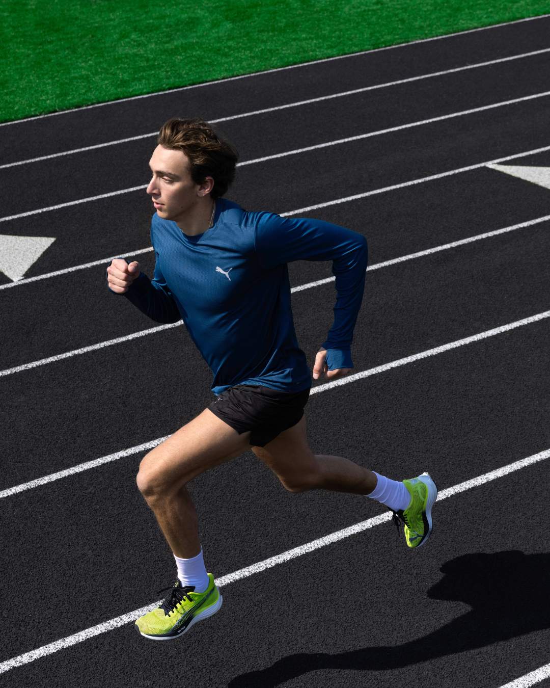 A man running on a track while wearing PUMA shoes