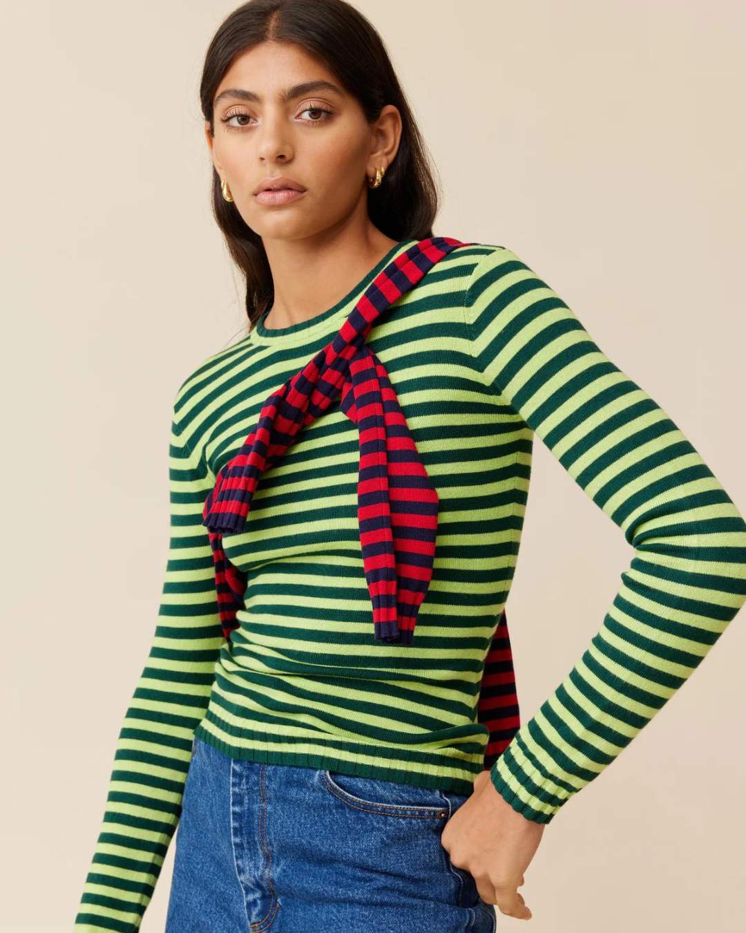 A model wearing a green striped long sleeve with a red long sleeve over top.