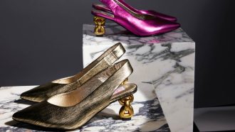 Two pairs of slingback heels. One is metallic pink and one is metallic pink. Both have a pointed toe and a chain heel.